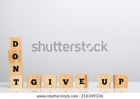 Don\'t Give Up Spelled in Letter Blocks on Studio Grey Background.