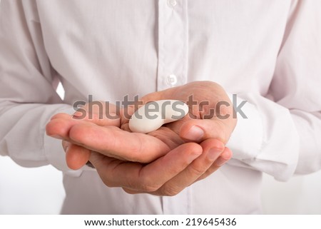 Close Up of Man Holding Small White Heart in Palm of Hands.