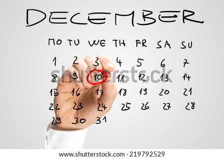 Man ringing Human Rights Day, Wednesday the 10th December, in red on a handwritten calendar on a virtual interface as a reminder to himself of its importance.