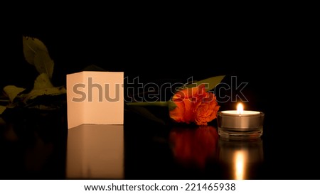 Romantic Still Life of Blank Card with Rose and Candle on Shiny Black Surface.