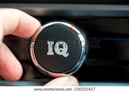 Hand of a man turning up a dial with the word IQ depicting increasing ones intelligence quotient.