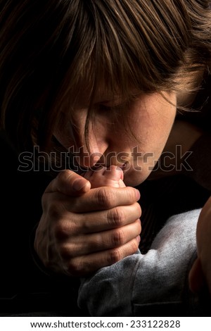 Close up Shot of Loving Mother Kissing the Small Hand of her Sleeping Baby on Black Background.