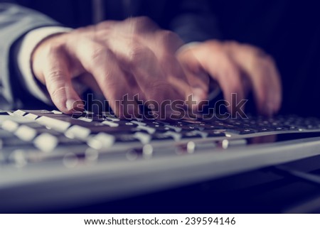 Retro image of a businessman typing on a computer keyboard inputting data with motion blur.
