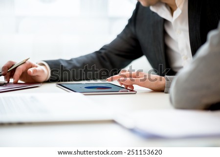 Businesswoman Discussing Business Matters with Her Male Colleague Using Tablet Computer Inside the Office.