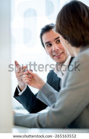 Side view of a businesswoman offering a pen to a businessman in order to close the deal with a signature. Focus on a pen.