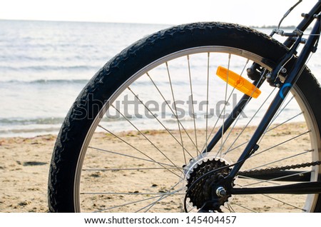 Close up on a bike wheel.Bike wheel at the seaside on the beach in summer.