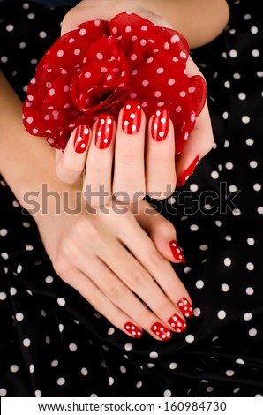Close Up On Beautiful Female Hand With Cute Red Manicure With White Dots. Black Dotted Background.