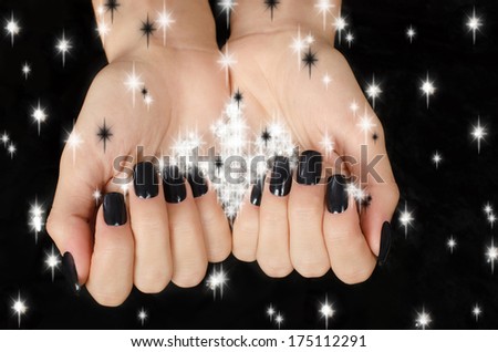 Close up on beautiful female hand with black manicure.