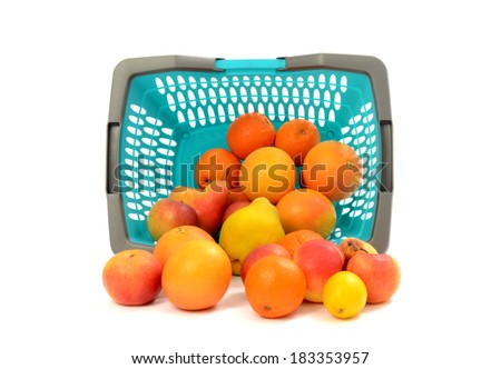 Blue plastic shopping basket full of fruits. Close up on plastic market basket turned over on the ground isolated on white.