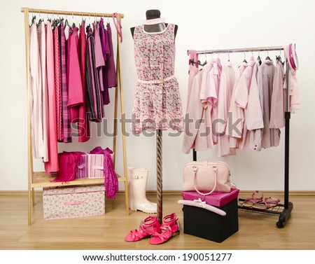 Dressing closet with pink clothes arranged on hangers and an outfit on a mannequin.  Wardrobe full of all shades of pink clothes, shoes and accessories.