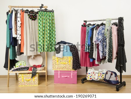 Dressing closet with polka dots clothes arranged on hangers. Colorful wardrobe with polka dots clothes on a rack and accessories.