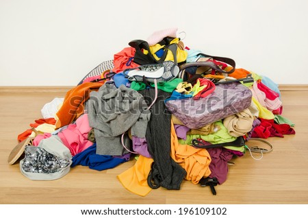 Big pile of clothes and accessories thrown on the ground. Untidy cluttered woman wardrobe all on the floor.