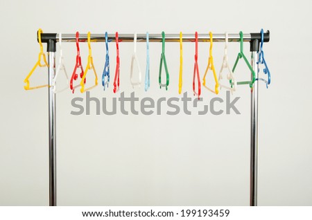 Rack of clothes with empty hangers. Colorful plastic hangers on display.
