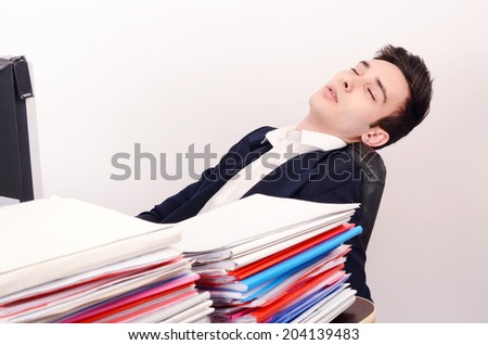 Tired business man sleeping at work. Exhausted worker sleeping at the desk.