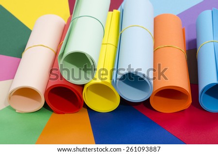 Roles of color paper. Color paper rolled and piled. Stack of paper on multicolor background.