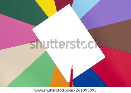 Red pencil and white sheet paper. Color pencil on a blank white paper with rainbow color paper background.