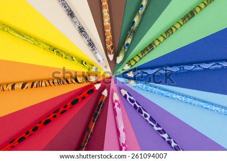 Unique design color pencils on paper. All colors pencils arranged in a circle on rainbow color paper.