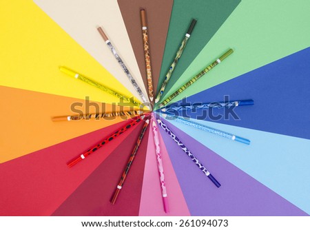 Unique design color pencils on paper. All colors pencils arranged in a circle on rainbow color paper.