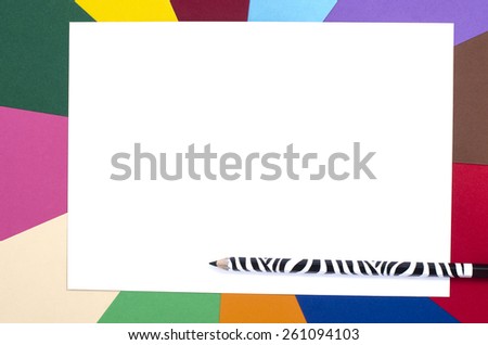 Black zebra design pencil and white sheet paper. Pencils on a blank white paper with rainbow color paper background.