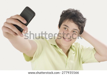 Happy young man taking a selfie photo with his smart phone. Man smiling looking at his mobile phone.