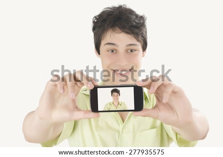 Happy young man taking a selfie photo with his smart phone. Man smiling looking at his mobile phone. Close up and focus on the mobile phone display.