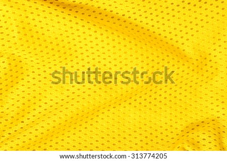 Yellow textile pattern as a background. Close up on yellow material with holes texture on fabric.
