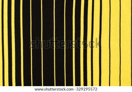 Striped black and yellow textile pattern as a background. Close up on vertical stripes material texture fabric.