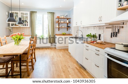 fancy kitchen interior kitchen table with tulips, green curtains and white cupboards
