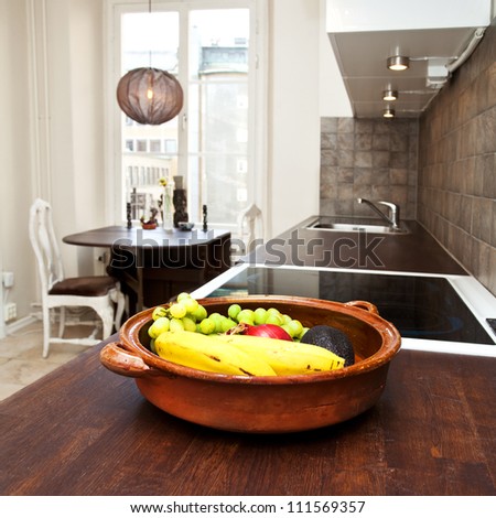 interior of a kitchen with a bowl of fruit in the foreground