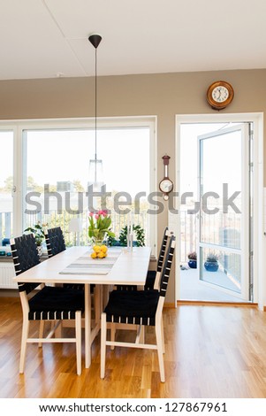 kitchen table by the window and open door to the balcony