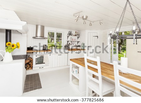 interior of a kitchen in the countryside with white wooden floor and ceiling