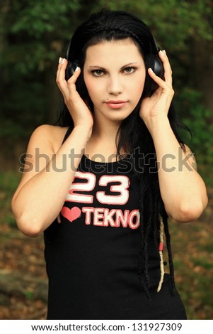 beautiful brunette with dreads and headphones in a shirt \