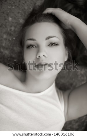 Portrait of a beautiful brunette in shirt on a ground, in nature, fashion photography, black and white photo