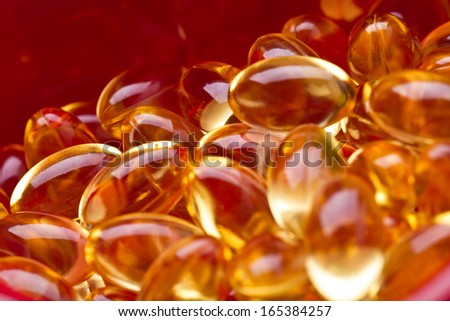 Cod liver oil omega 3 gel capsules isolated on pastel background. Vitamin d pils. Pils in Hearth shape bowl