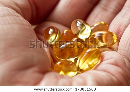 Cod liver oil omega 3 gel capsules isolated on wooden background. Vitamin d capsuls. Fish oil supplements