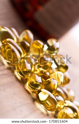 Cod liver oil omega 3 gel capsules isolated on wooden background. Vitamin d capsuls. Fish oil supplements