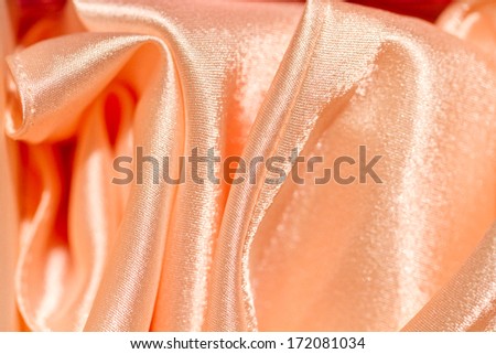 Chaotic drapery of delicate pink satin. pastel satin texture
