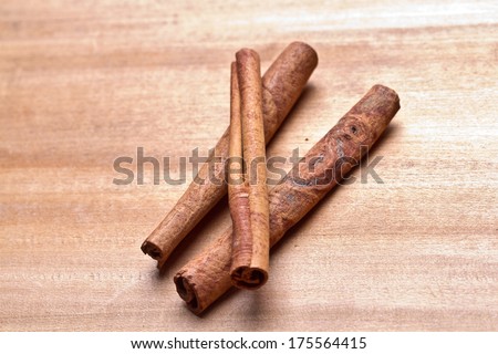 Stack of cinnamon with its dust around it over a white background