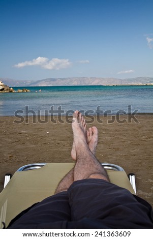 Young man legs sunbathing on the beach
