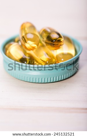 Cod liver oil omega 3 gel capsules isolated on wooden background. Vitamin D capsules. dietary supplement