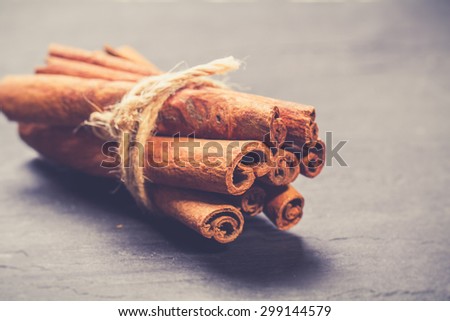 Bunch of cinnamon sticks on rustic wooden table. Vintage food photo