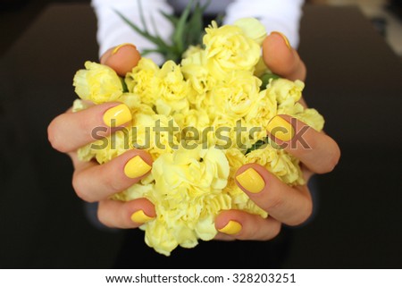 Carnations in hands with yellow nails