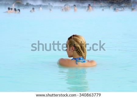 A woman stands back to us in blue lagoon spa resort in Iceland
