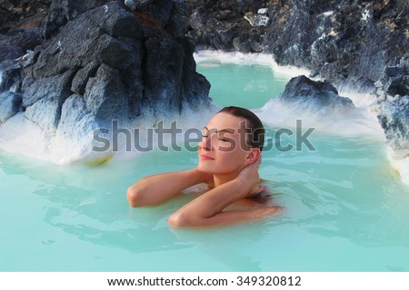 Woman with closed eyes relaxes and enjoys of spa in hot spring Blue Lagoon in Iceland
