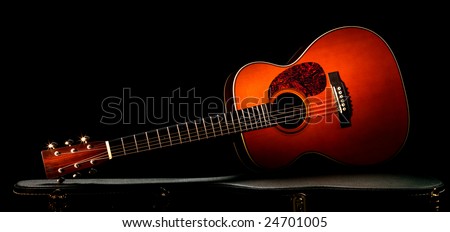 acoustic guitar lying on the case, dramatic lighting.