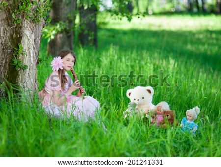 Girl in pink dress playing the flute favorite toys