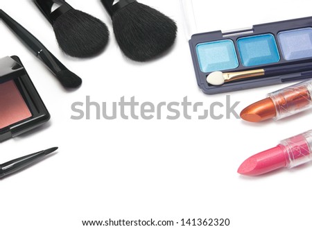 Eye shadow, lipstick, blush and makeup brushes on white background