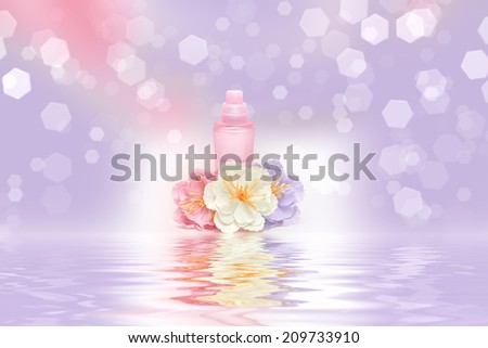 Perfume bottle with flowers reflected in the water surface. Cool and floral fragrance concept