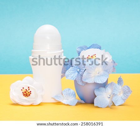 Close-up of body antiperspirant deodorant roll-on with white and blue flowers in the cap