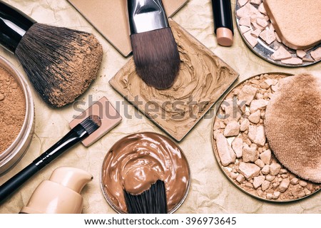 Makeup products to even skin tone and complexion on aged paper. Corrector, loose and compact powders, concealer pencil, liquid foundation with brushes and cosmetic sponges. Retro style processing